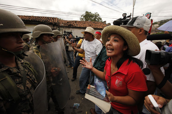 Honduras crisis: A supporter of Honduras' ousted President Manuel Zelaya shouts to soldiers