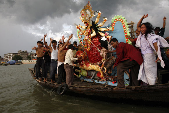 Eyewitness: Hindus prepare to immerse an idol of the goddess Durga in the river