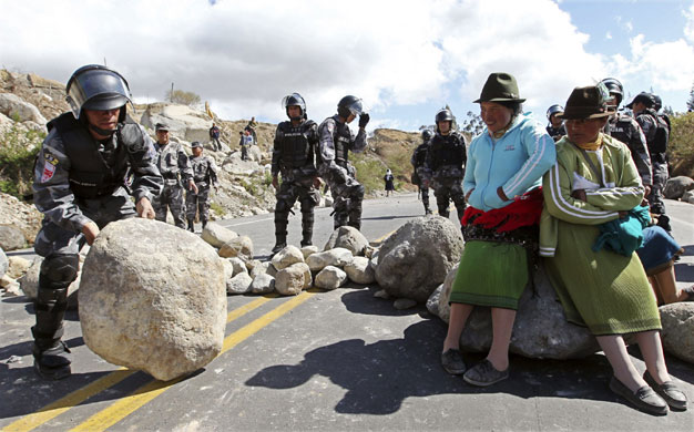 29 September 2009: Guachala, Ecuador: A police officer removes a rock to clear a road