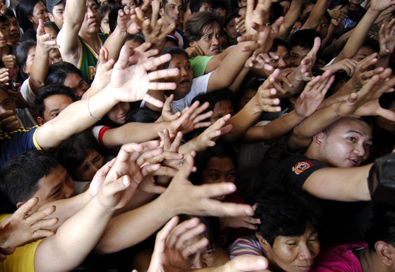 29 September 2009: Marikina, Philippines: Flood survivors reach out for relief goods