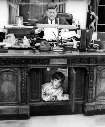 The Obama family: 1963:  John Jr under his father's desk in the Oval Office