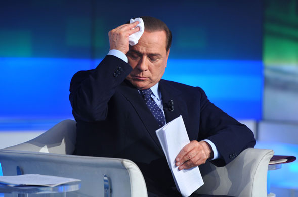 Sweating politicians: Prime Minister Silvio Berlusconi wipes his brow on a TV programme