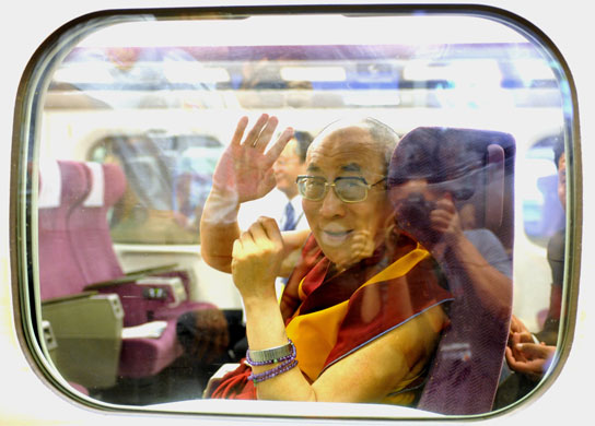3 September 2009: Tsaoying, Taiwan: The Dalai Lama waves from a train
