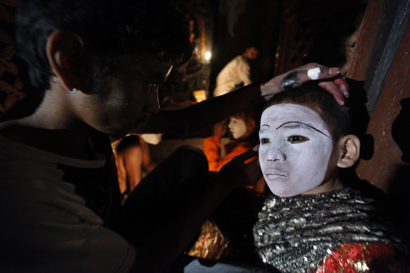 3 September 2009: Hanuman Dhoka, Nepal: A make-up artist dresses boys for a traditional dance