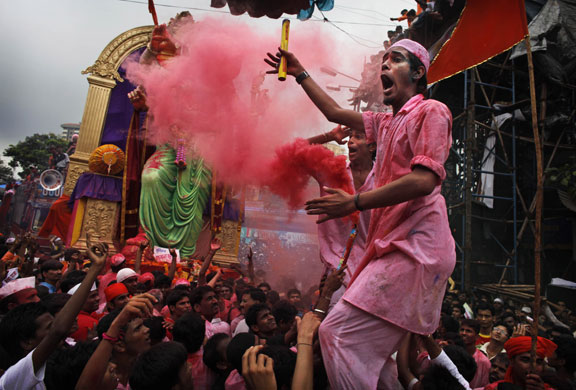 3 September 2009: Mumbai, India: Hindu devotees dance in front of a large statue