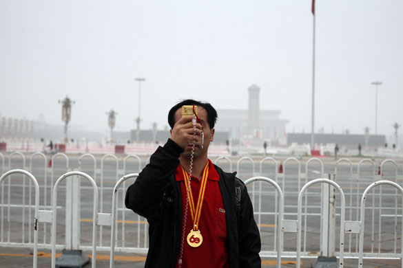 30 September 2009: Beijing, China: A man snaps a picture with a cell phone