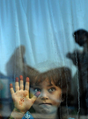 30 September 2009: Karachi, Pakistan: An internally displaced girl sits on a bus at a terminal