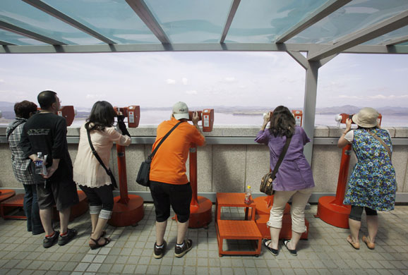 4 September 2009: South Korea: Japanese tourists look at a village in North Korea