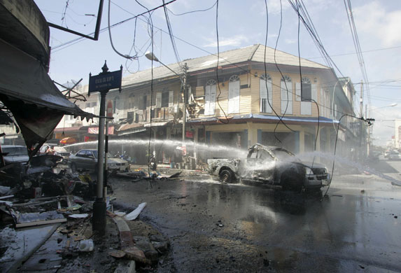 4 September 2009: Yala province, Thailand: Firefighters extinguish a fire on a pick-up truck
