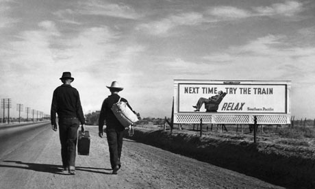 Two men walking along a dusty depression-era road, USA