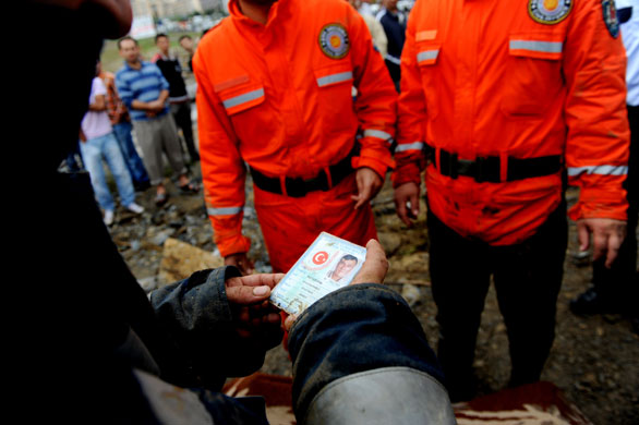 Flooding in Turkey: Rescue workers and policeman look at the identity card of a victim