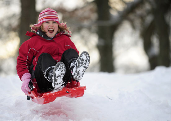 Cold weather continues: 9 January, Pitlochry, UK: A girl enjoys sledging in the snow