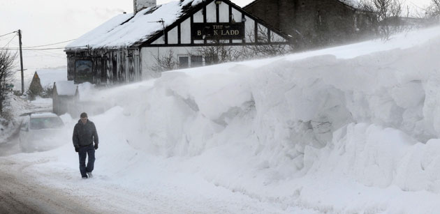 Cold weather continues: 10 January, Shaw, UK: A man walks past a wall of snow