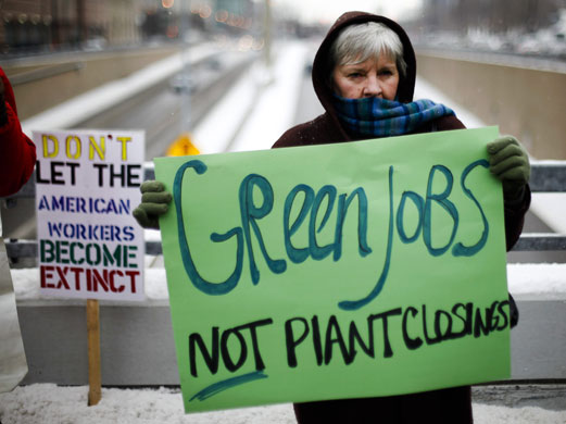 Detroit motor show: A woman holds a placard outside the show during press day