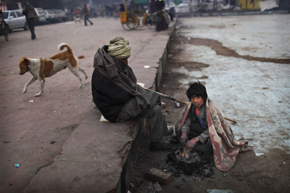 24 hours in pictures: Delhi, India: Impoverished men try to keep themselves warm