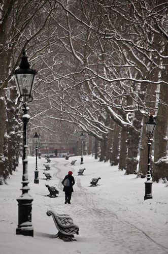 Snow again: A woman makes her way across snow-covered Green Park in London