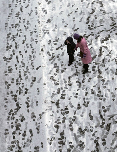24 hours: Lausanne, Switzerland: A woman and a child walk in the snow