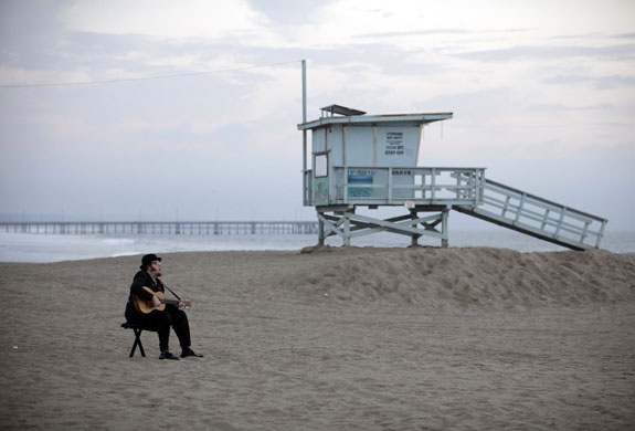 24 hours: A man plays the guitar on Venice Beach in Los Angeles