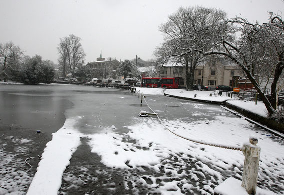 Snow again: Traffic passes half frozen Carshalton Ponds