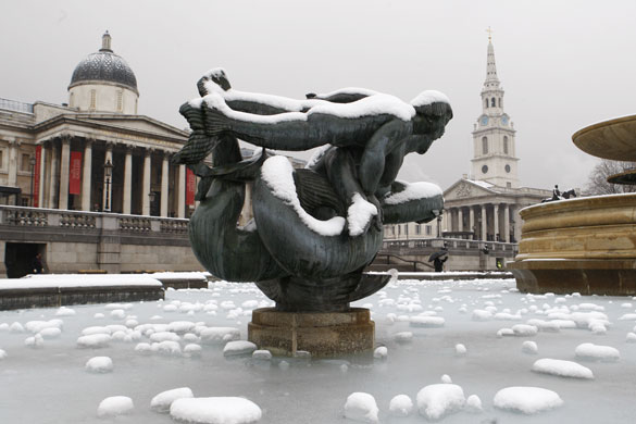 Snowing again: Snow and ice cover one the fountains in London's Trafalgar Square