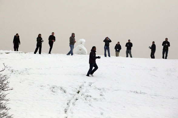 Snowing again: Office workers host a impromptu snow ball fight outside their offices