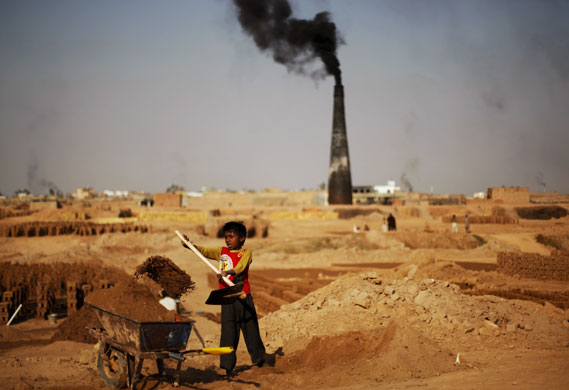 24 hours in pictures: Islamabad, Pakistan: A boy shovels clay while working at a brick factory