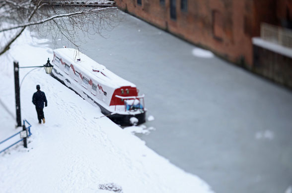 24 hours in pictures: Birmingham, UK: A member of the public makes the snow
