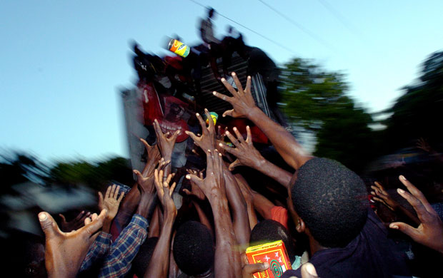 History of Haiti: Haitians struggle to reach a can of food after floods in 2004