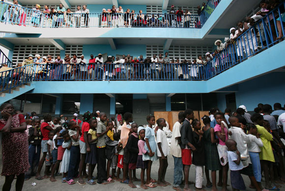 History of Haiti: Refugees line up to get food after tropical storm Noel