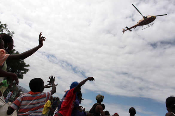 haiti quake: People wave at a helicopter in the center of Port-au-Prince
