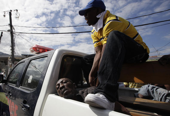 haiti quake: Police guards a detained man accused of trying to steal food in a market 