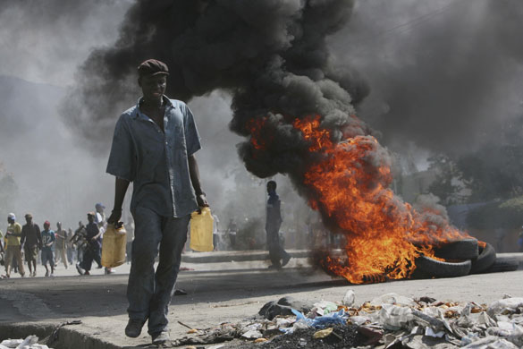 History of Haiti: 2008: A man walks past a burning barricade during an anti-government demo