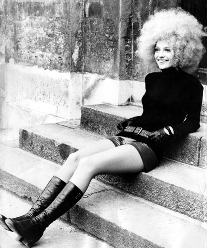 Teenage Hair: A white girl with afro style hair sits on steps