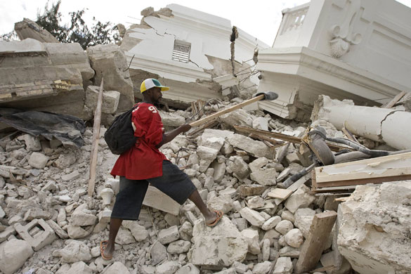 Rescue efforts in Haiti: A man recovers a shoe from the rubble of the collapsed Justice Palace