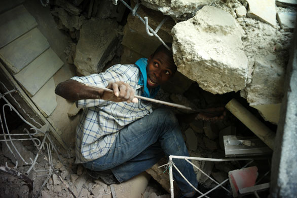 Rescue efforts in Haiti: A man tries to rescue a woman in the rubble in Port-au-Prince