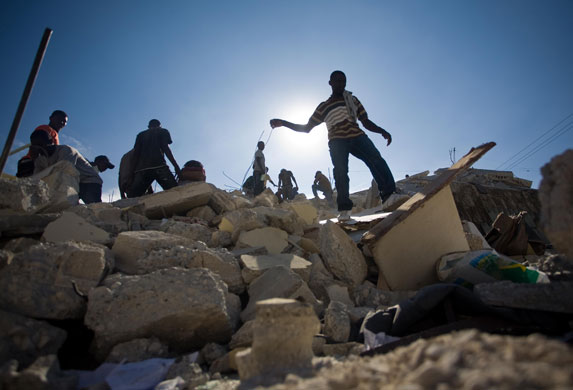 Rescue efforts in Haiti: People try to clear debris of destroyed buildings in Port-au-Prince 
