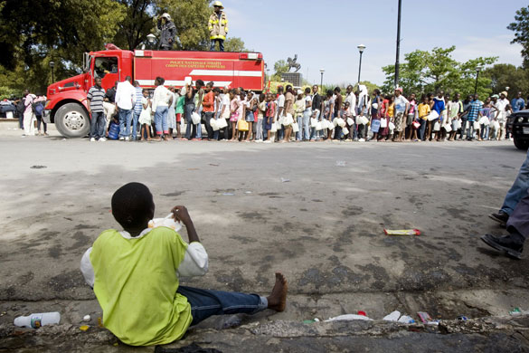 Rescue efforts in Haiti: A young boy watches people lining up to receive water 