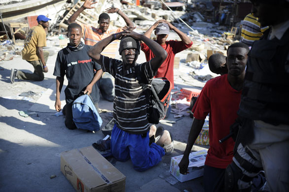 24 Hours in Pictures: Looters are arrested by policemen in a street of Port-au-Prince