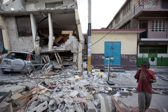 David Levene in Haiti: A child covers his face in a street of damaged buildings in Port-au-Prince