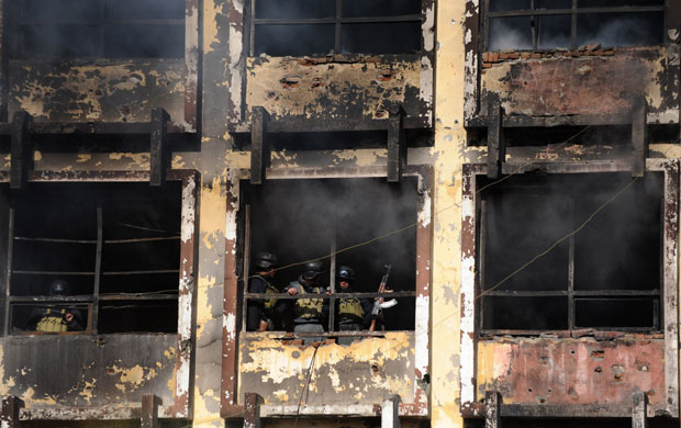 Kabul violence: Afghan policemen take position in a public market building during clashes