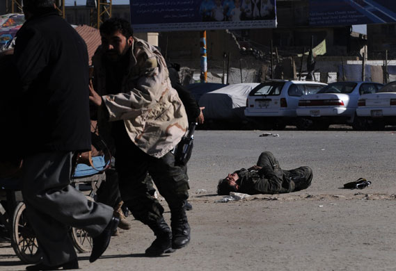 Kabul violence: An injured Afghan commando lies on the ground during clashes