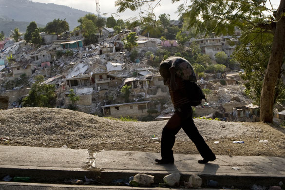 Lawless Haiti: A Haitian man carries his possessions past a destroyed neighbourhood