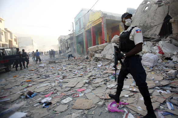 Lawless Haiti: A police officer patrols downtown Port-au-Prince to discourage looting