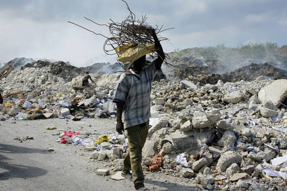Lawless Haiti: A man carries a bundle of metal bars salvaged from the rubble 