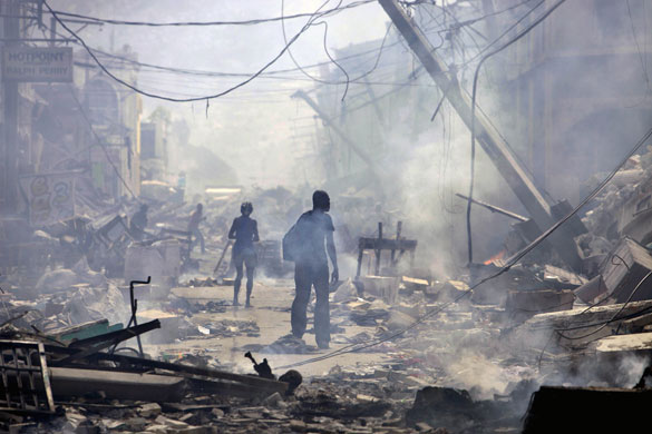 Lawless Haiti: People walk down a street with several fires burning in Port-au-Prince