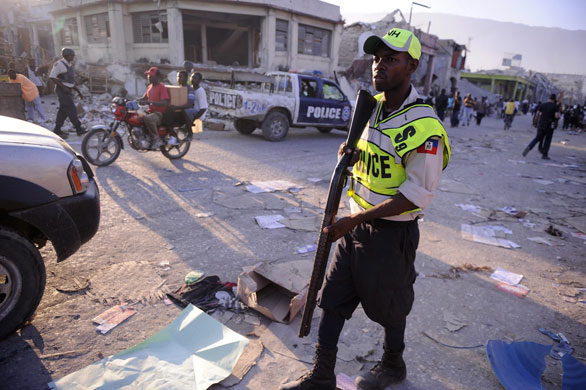 Lawless Haiti: A Haitian national police officer on patrol after firing on looters