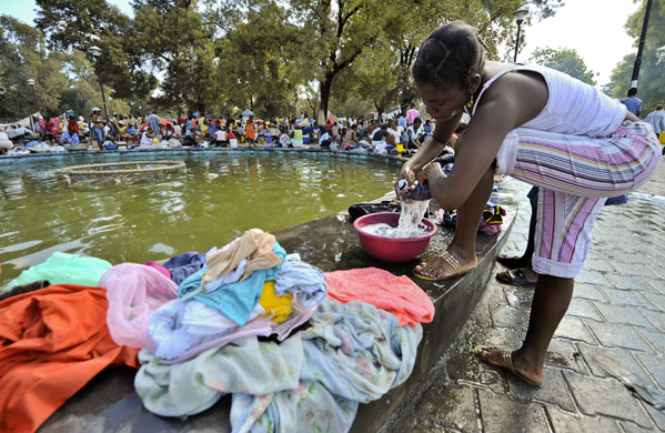 Lawless Haiti: A Haitian woman washes her clothes at the Jean Jacques Dessalines park