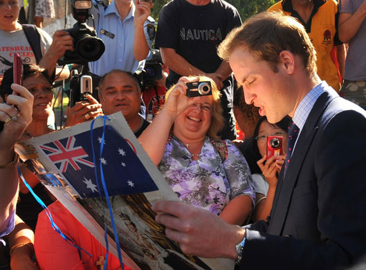 Prince William down under: 19 January: Prince William studies a home-made photo montage
