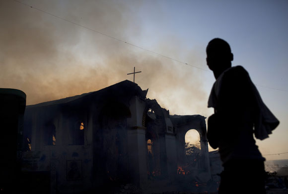 Haiti Aid: man stands in front of a burning church