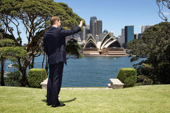 Prince William down under: Prince William waves to a passing boat during a visit to Admiralty House